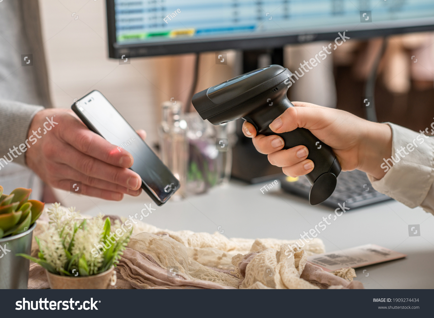 A shopper checking a price on their phone in a thrift store