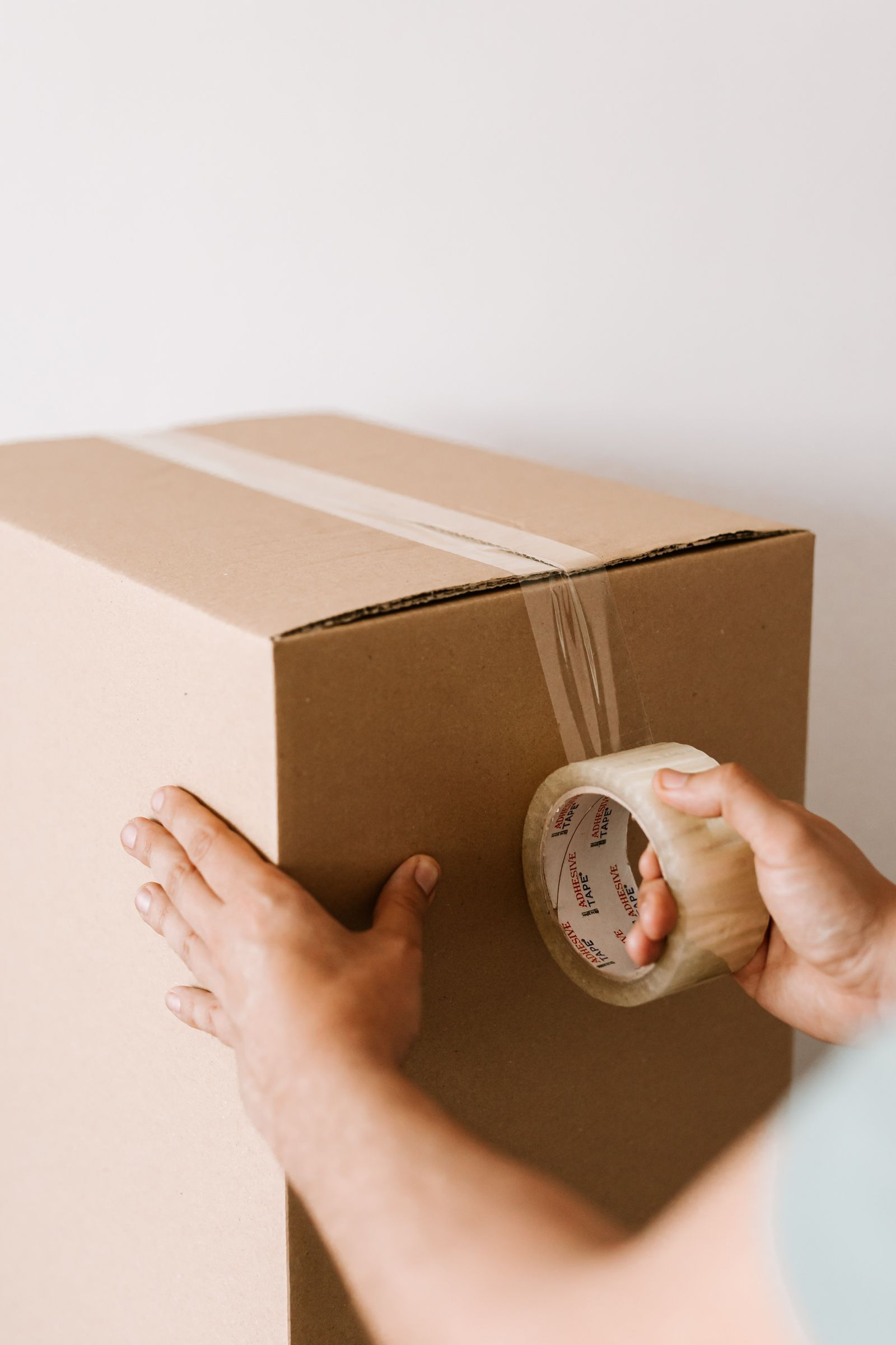 A roll of packing tape resting on a sealed cardboard box