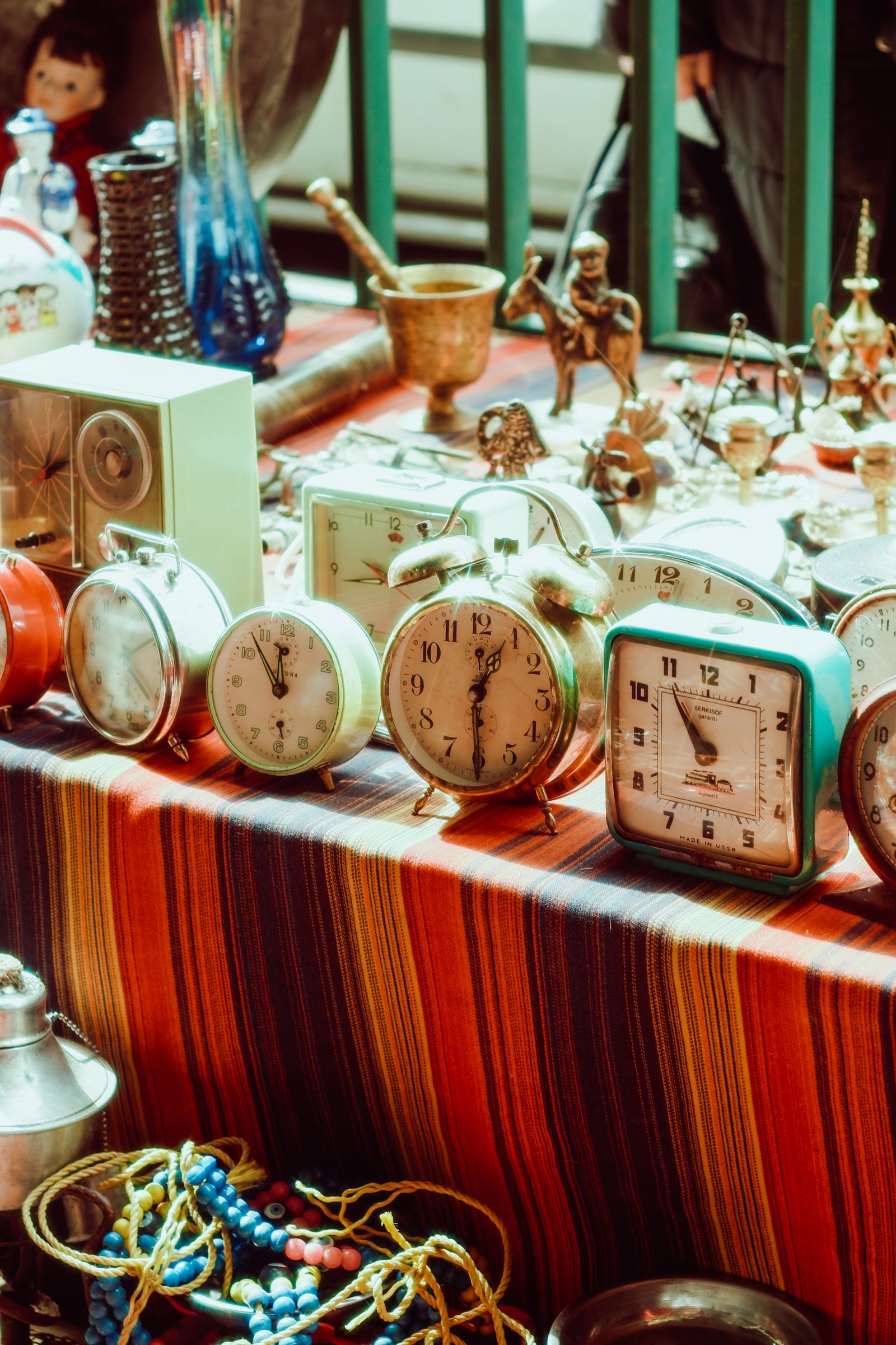 An analogue alarm clock on a bedside table