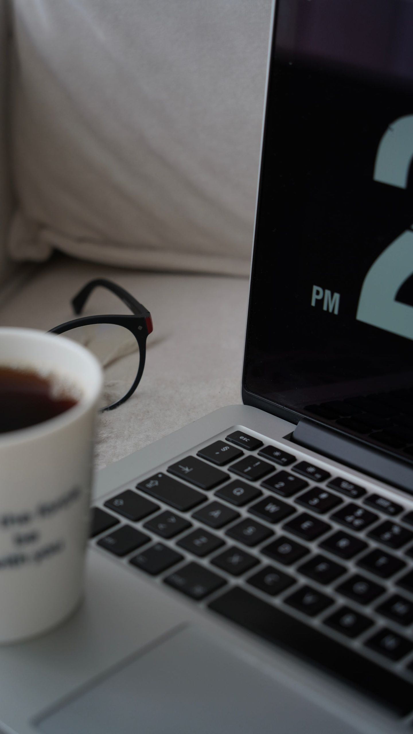 An open laptop on a plain wooden desk