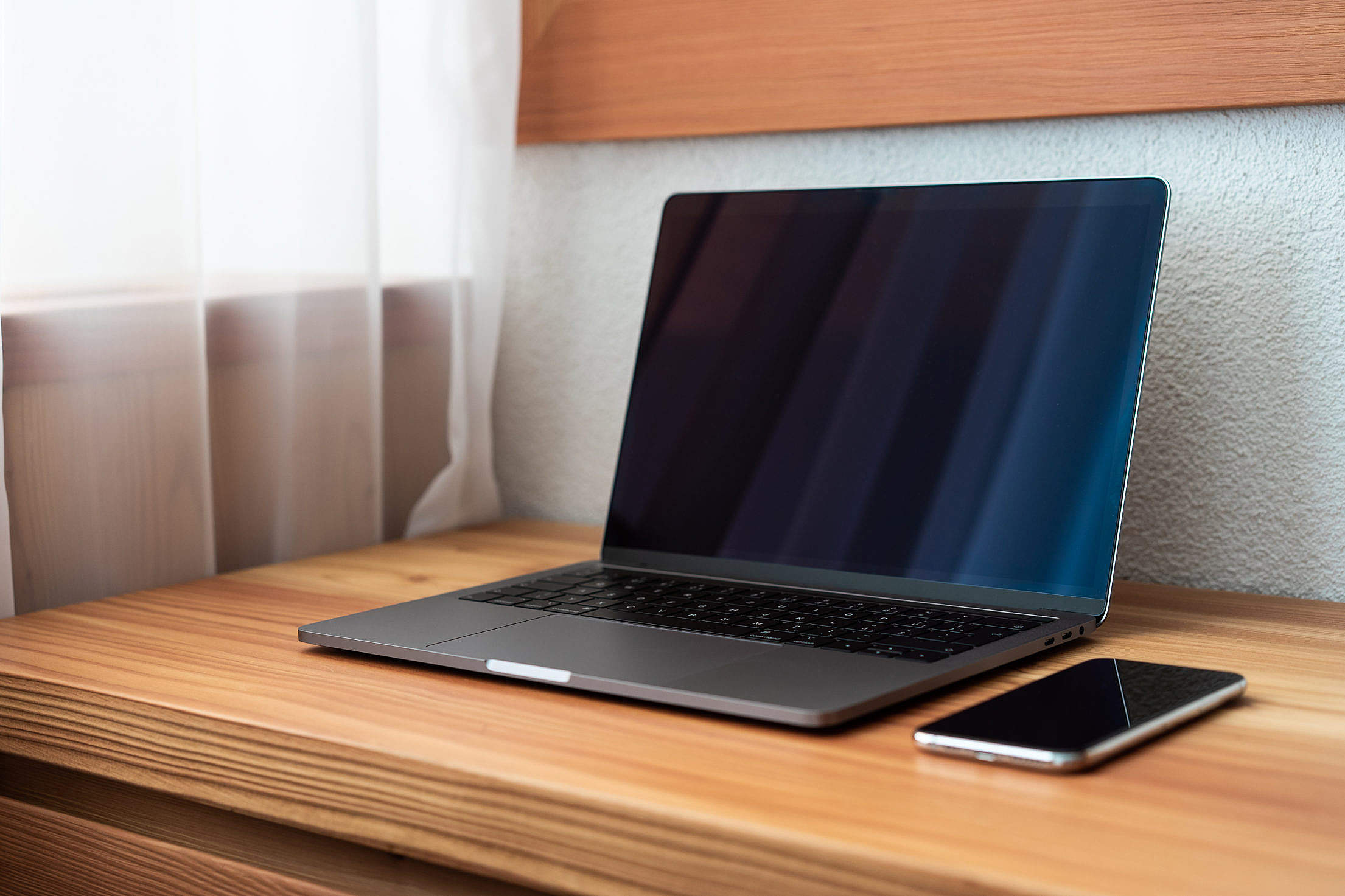 An open laptop on a wooden desk