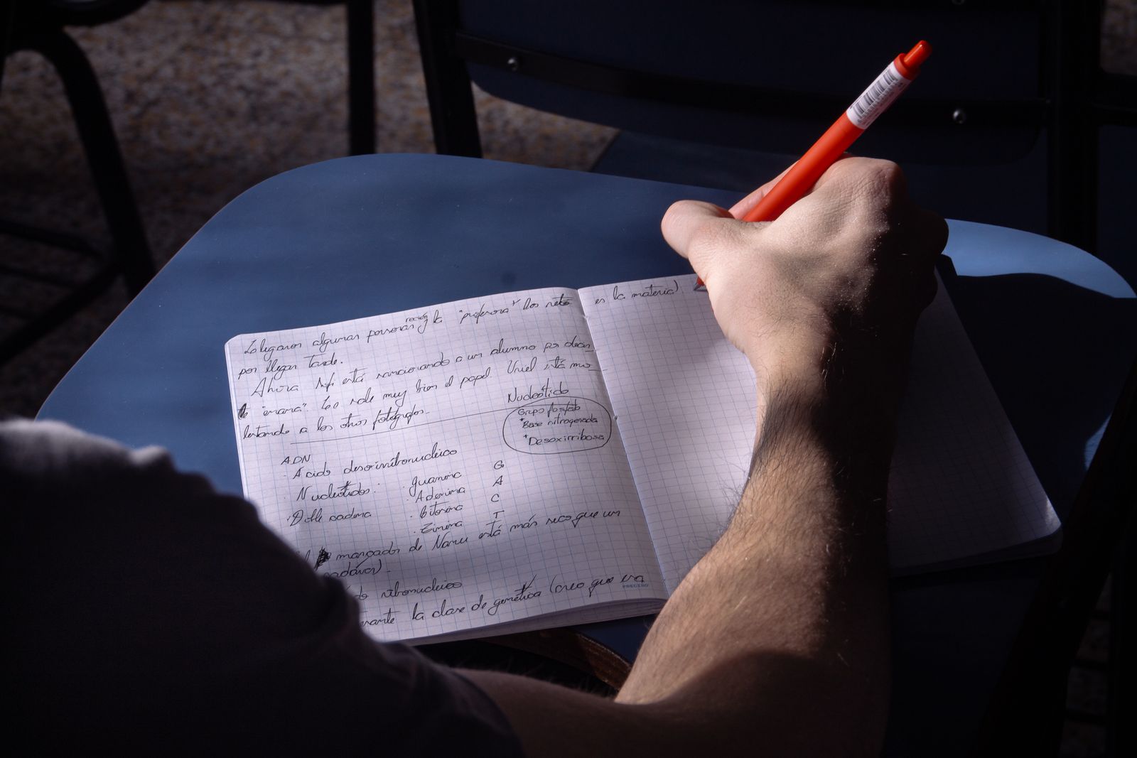 A notebook and coloured pencils arranged on a desk