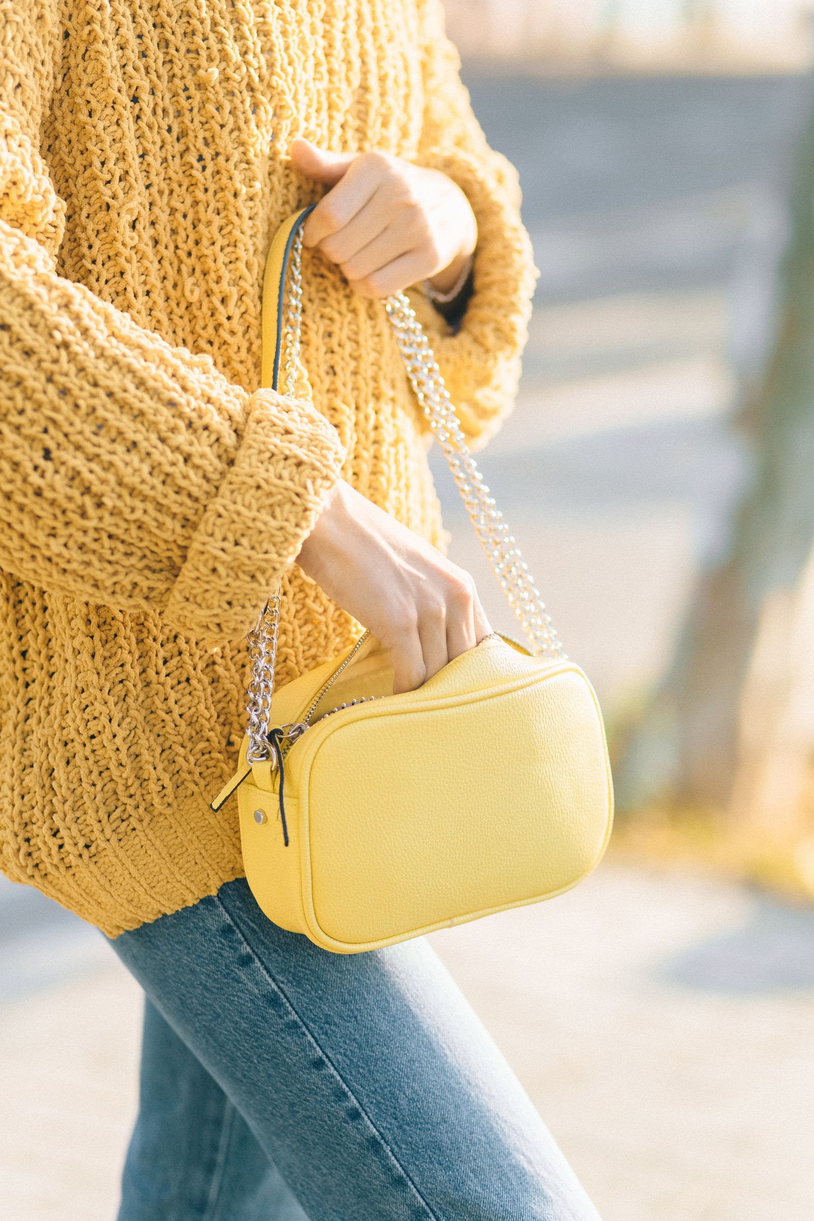 A structured leather handbag sitting on a chair
